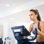 Alt: a woman touching a cardio machine.