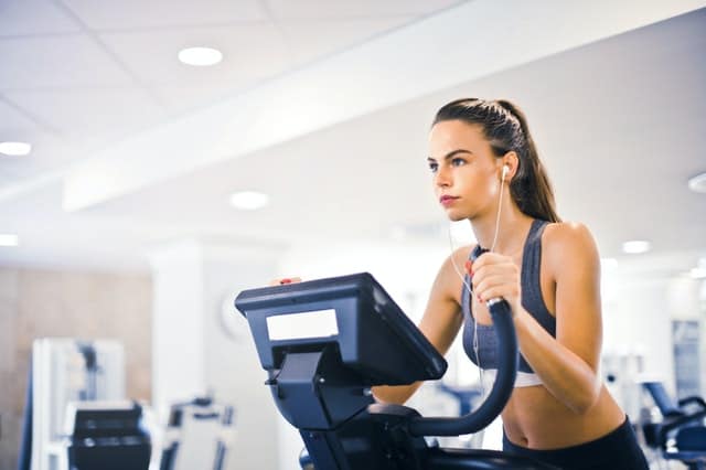 Alt: a woman touching a cardio machine.