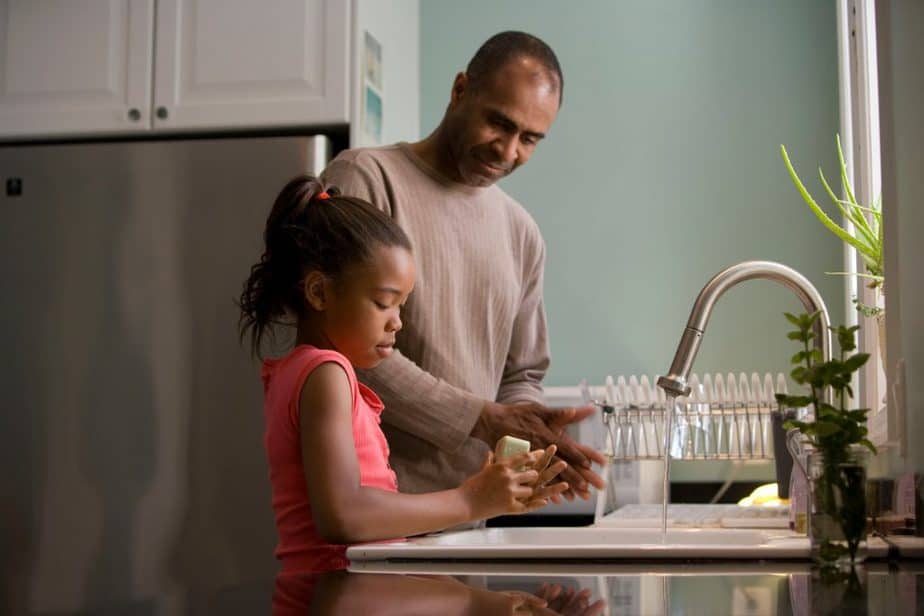 Caption: Quality is more important than quantity A father teaching his daughter to wash hands properly